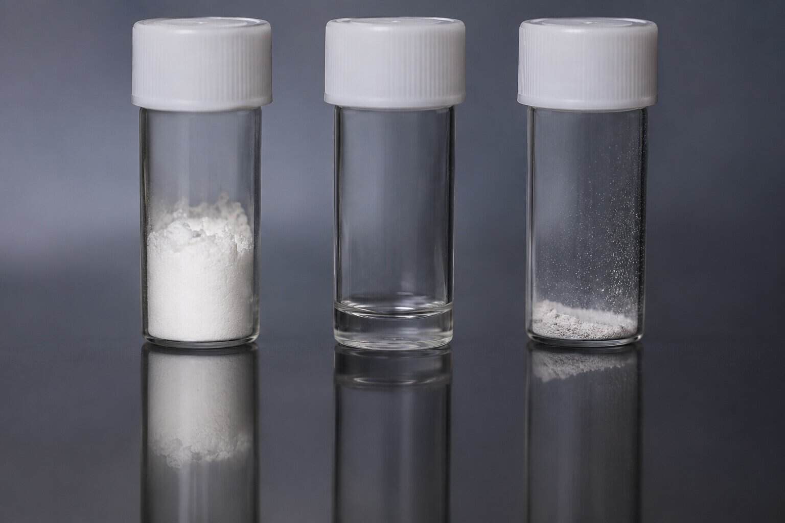 Three clear sample vials containing different amounts of white powder on a reflective surface for an article about fentanyl identification.