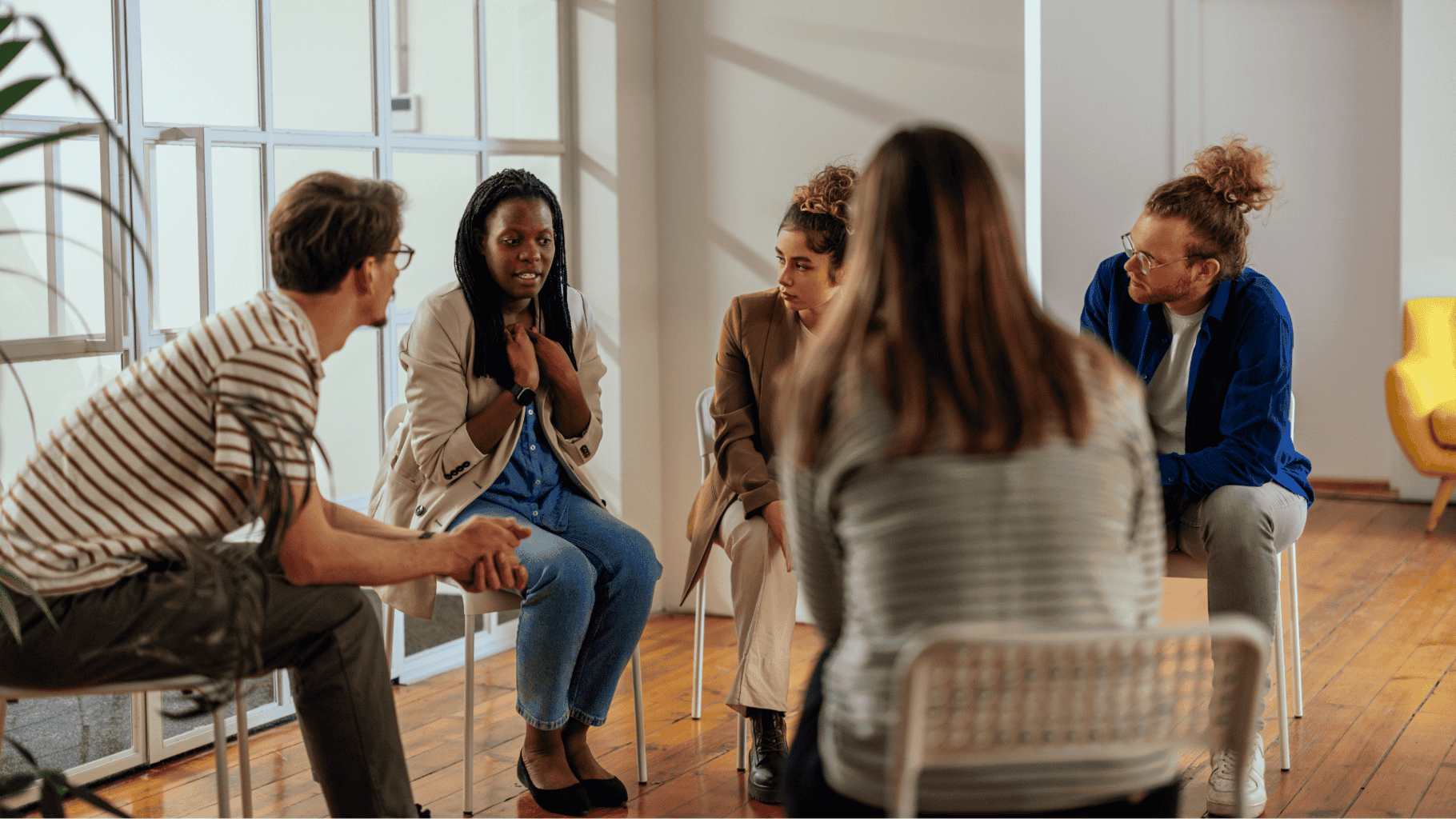 Addiction aftercare support group discussing recovery together